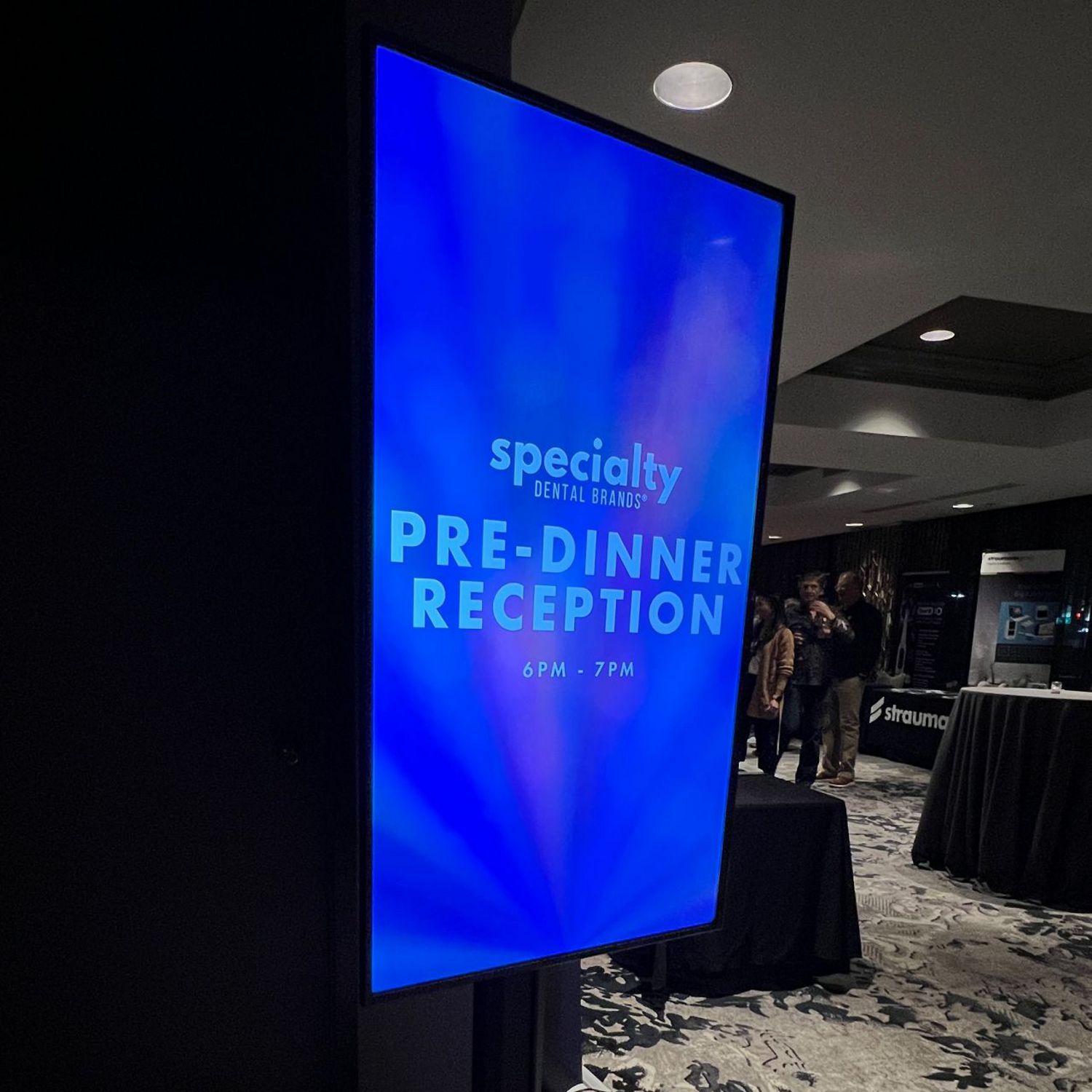 A bright blue digital sign displays the words 'specialty dental brands pre-dinner reception.'