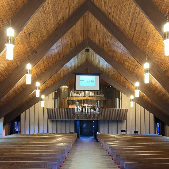 A digital screen hangs from the back of a gorgeous church sanctuary over the pipe organ.