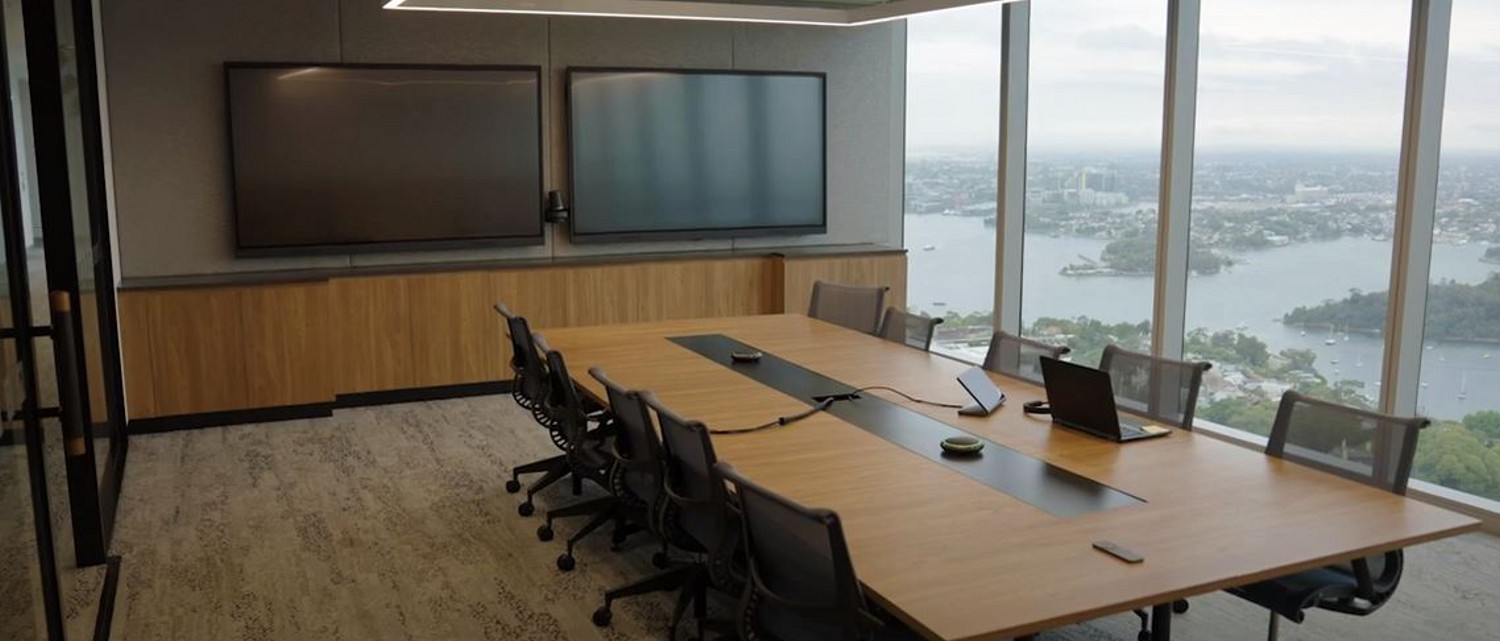 A beautiful meeting room with a complete conference room AV system; 2 wall-mounted displays, speakers, and video camera.