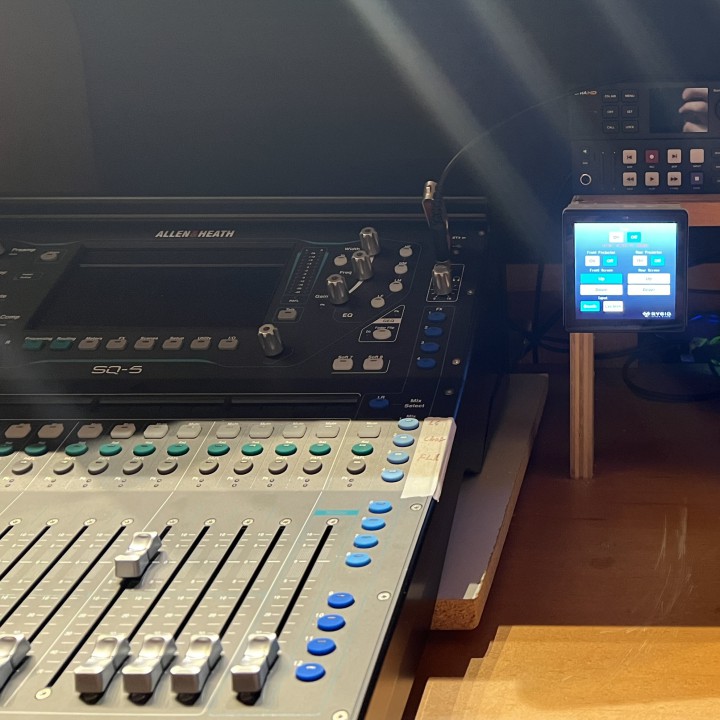 A video switch, recorder, and streamer next to a digital sound board.