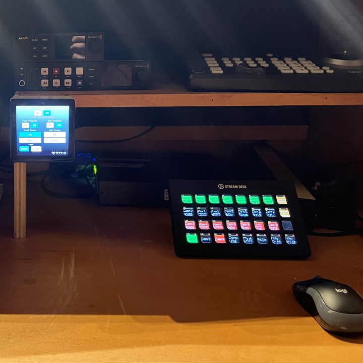 An Elgato stream deck surrounded by audio-visual equipment for a church sound system.
