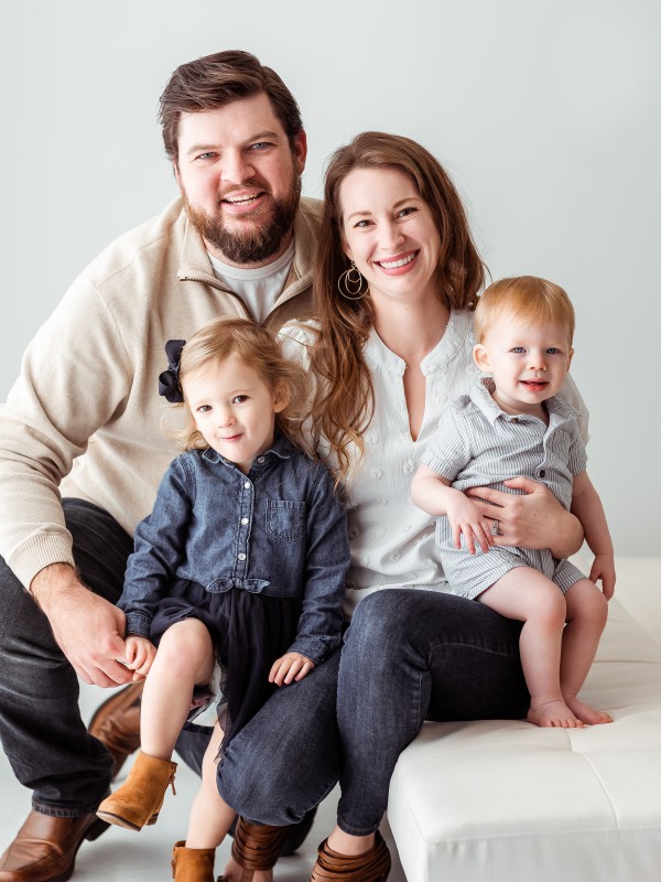 Ryan Gilbert in a family portrait with his wife and two kids.