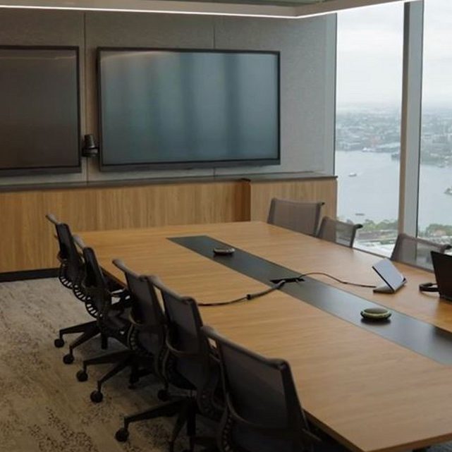 A beautiful meeting room with a complete conference room AV system; 2 wall-mounted displays, speakers, and video camera.